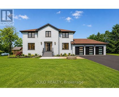 A white house with a brown roof and a garage door is for sale by Zolo Realty Brokerage.