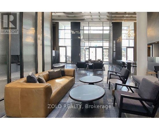 A modern waiting area with a sofa, chairs, and tables.