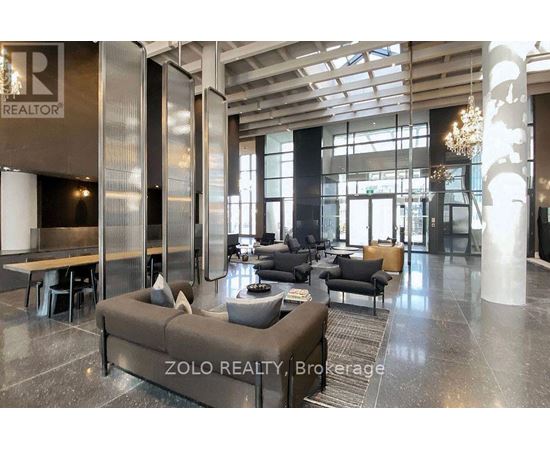 A modern living room with a large sofa and a chandelier.