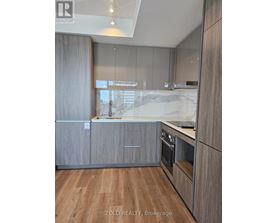 A modern kitchen with wooden cabinets and a marble countertop.
