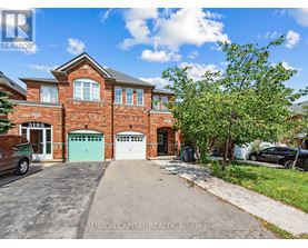 A brick house with a green garage door is for sale.