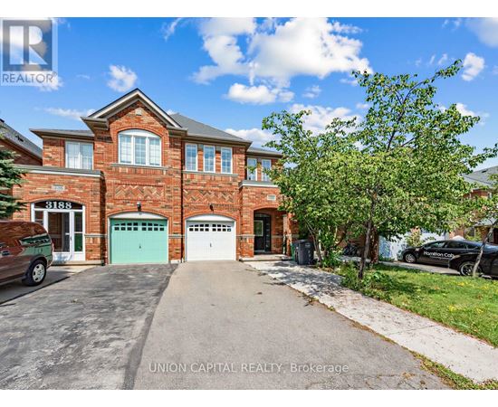 A brick house with a green garage door is for sale.