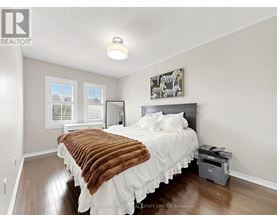 A bedroom with a bed covered in a brown and white comforter.