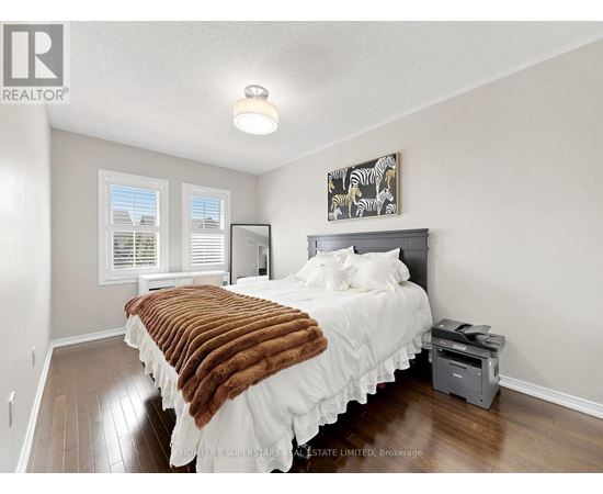 A bedroom with a bed covered in a brown and white comforter.