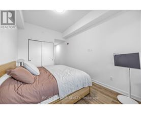 A bedroom with a bed, pillow, and a lamp.