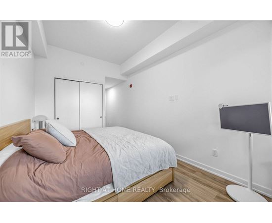 A bedroom with a bed, pillow, and a lamp.