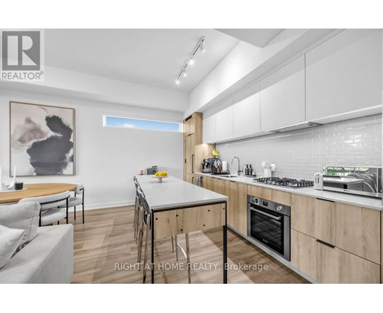 A modern kitchen with wooden cabinets and a dining table.