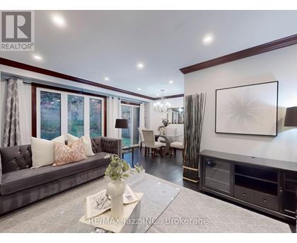 A living room with a grey couch, a coffee table, and a large painting on the wall.