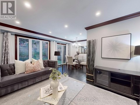 A living room with a grey couch, a coffee table, and a large painting on the wall.