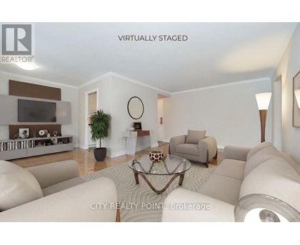 A living room with a white couch and a glass coffee table.