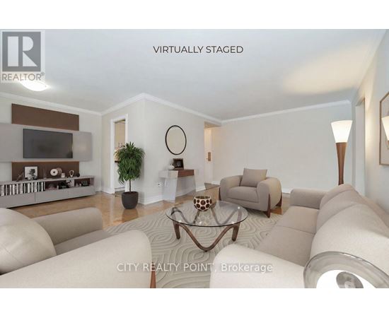 A living room with a white couch and a glass coffee table.