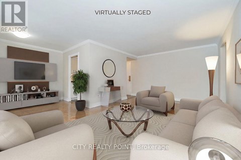 A living room with a white couch and a glass coffee table.