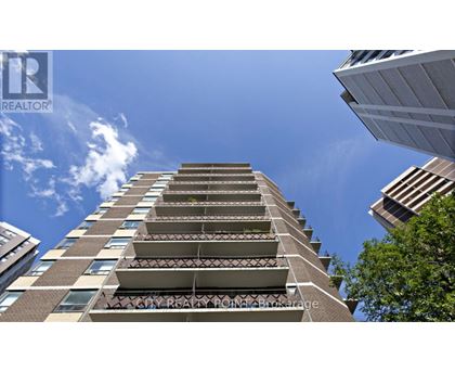 A tall residential building with balconies on the upper floors.