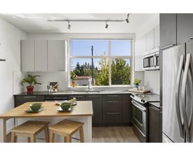 A modern kitchen with a table and chairs in front of a window.