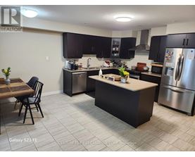 A kitchen with a table and chairs in front of a refrigerator.