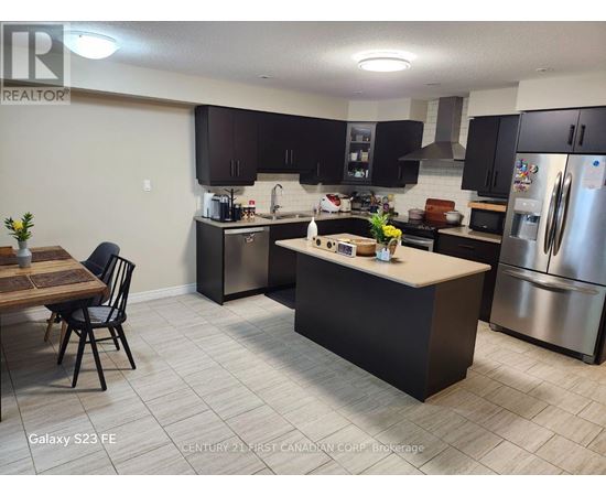 A kitchen with a table and chairs in front of a refrigerator.