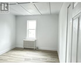 A room with a window and a radiator on the floor.