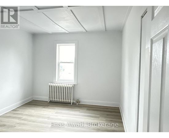 A room with a window and a radiator on the floor.