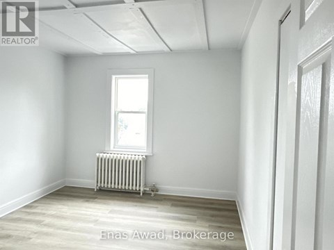 A room with a window and a radiator on the floor.