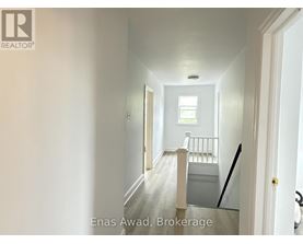 A hallway with a door on the right and a window on the left.