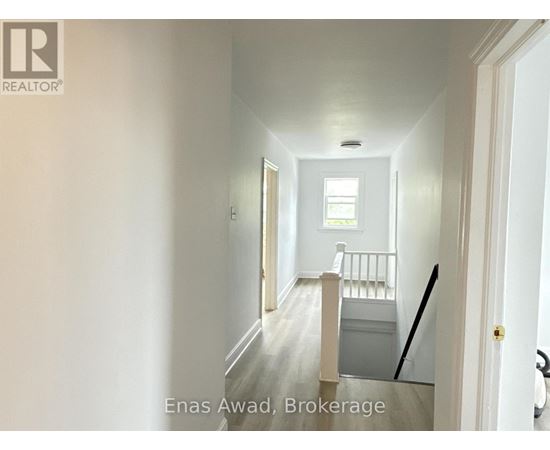 A hallway with a door on the right and a window on the left.