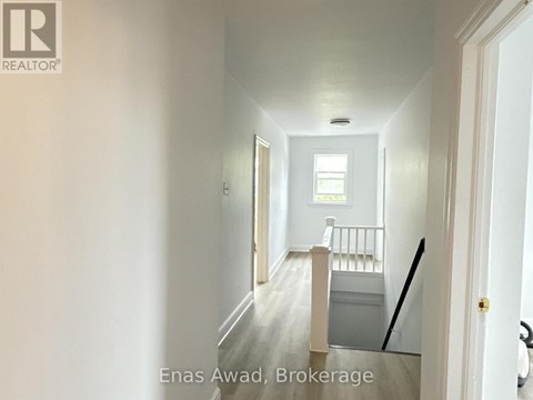 A hallway with a door on the right and a window on the left.