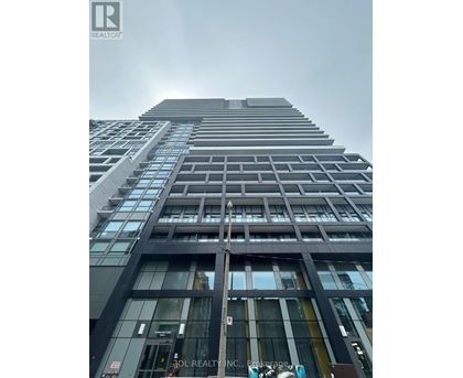 A tall building with a glass facade and a sign that reads "ADL REALTY INC. Brooklyn.".