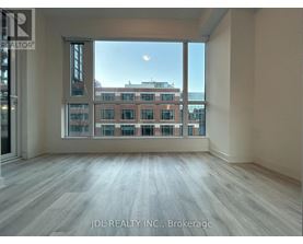 A spacious room with a view of a cityscape through large windows.