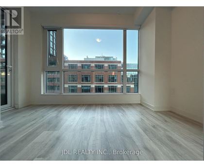 A spacious room with a view of a cityscape through large windows.