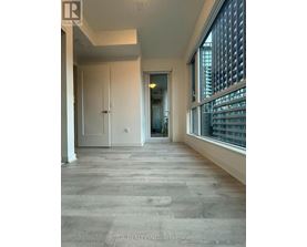 A spacious room with a doorway leading to another room.