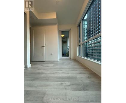 A spacious room with a doorway leading to another room.