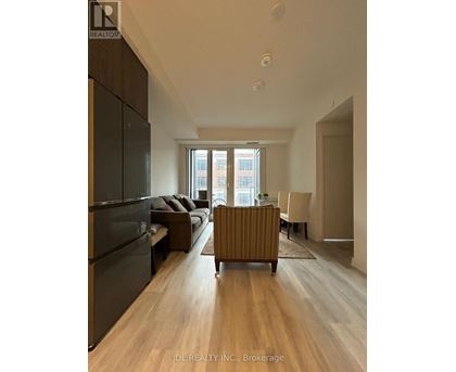 A modern living room with a dark wood floor and furniture.