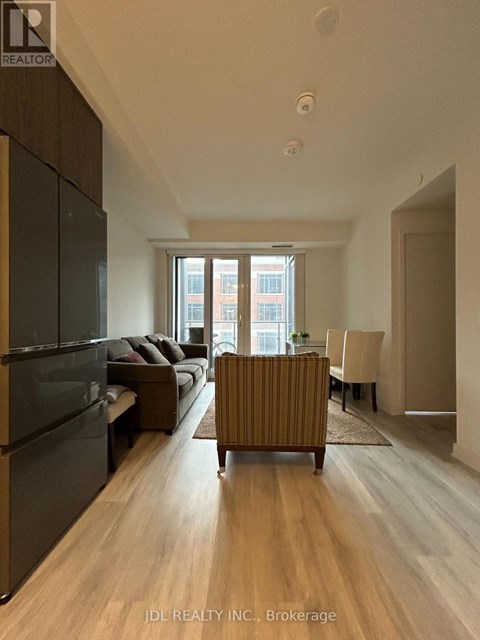 A modern living room with a dark wood floor and furniture.