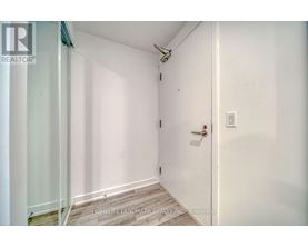 A white door with a handle and a light switch on the wall.