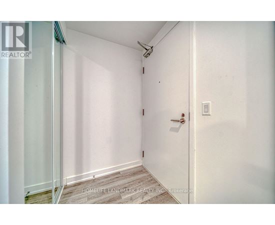 A white door with a handle and a light switch on the wall.