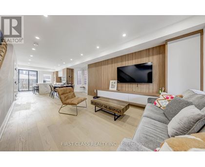 A living room with a grey couch and a wooden wall.