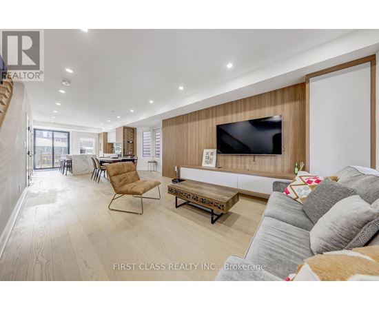A living room with a grey couch and a wooden wall.