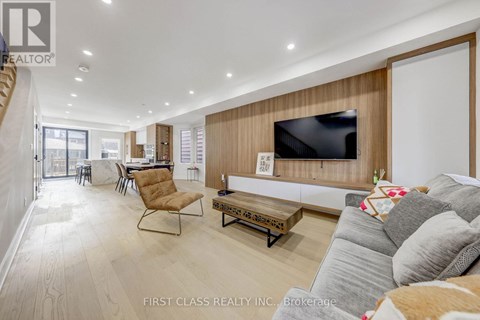A living room with a grey couch and a wooden wall.
