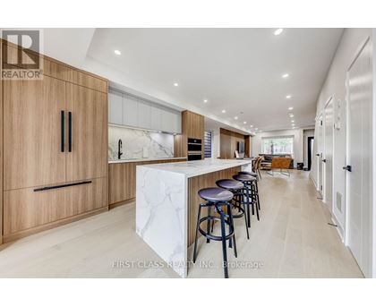 A modern kitchen with wooden cabinets and a marble island.