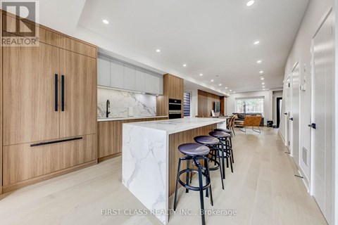 A modern kitchen with wooden cabinets and a marble island.