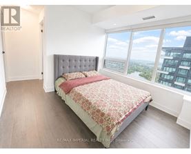 A bedroom with a large bed and a view of the city.