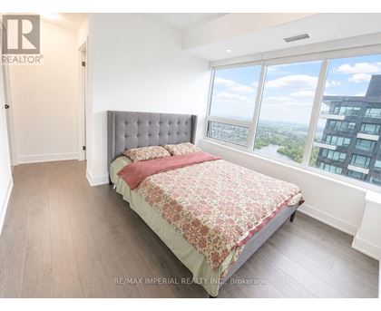 A bedroom with a large bed and a view of the city.