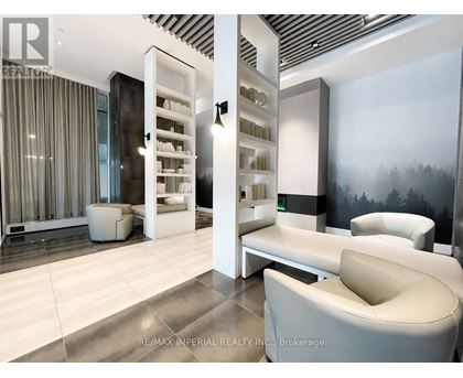 A modern living room with a white sofa and a glass cabinet.