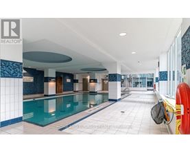 A swimming pool inside a building with a sign that says "POOL WAITING ROOM".