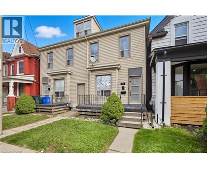 A row of houses with a Realtor sign in front of the first one.