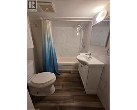 A white toilet sits next to a white sink in a bathroom.