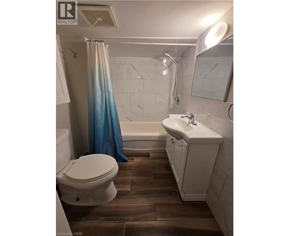 A white toilet sits next to a white sink in a bathroom.