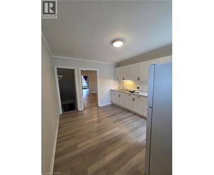 A kitchen with white cabinets and a refrigerator.
