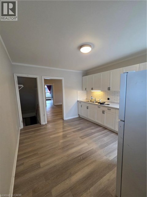 A kitchen with white cabinets and a refrigerator.
