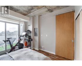 A room with a bed, a gym equipment and a window.